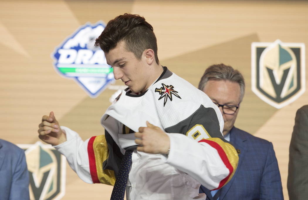 Peyton Krebs puts on a Vegas Golden Knights jersey during the first round of the NHL hockey dra ...