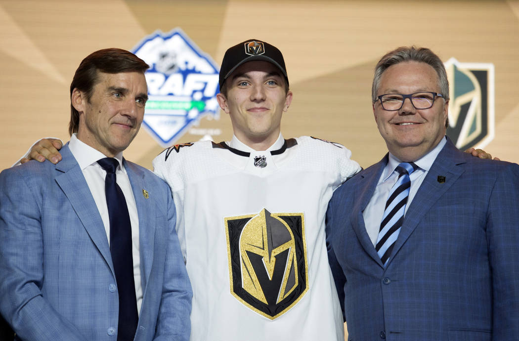 Vegas Golden Knights pick Peyton Krebs, center, poses during the first round of the NHL hockey ...