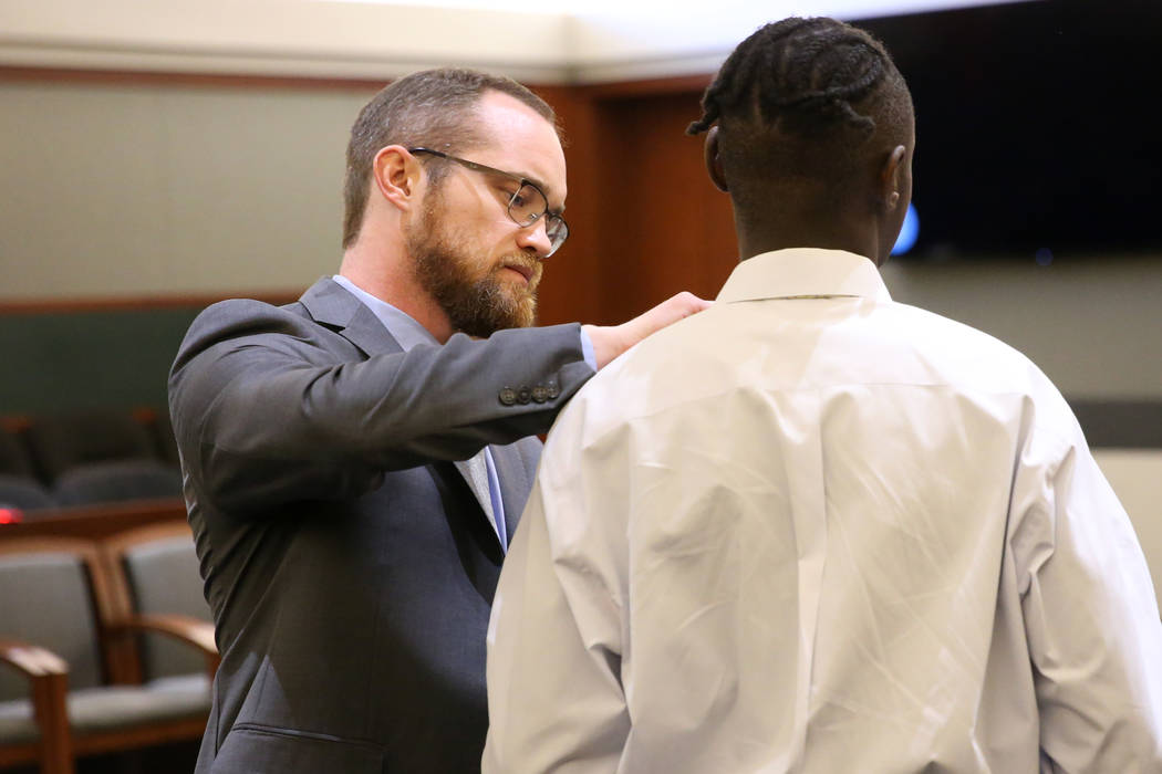 Defense lawyer Chris Peterson, left, helps his client Weslie Martin remove his necktie followin ...