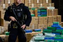 An officer stand guard over a fraction of the cocaine seized from a ship at a Philadelphia port ...