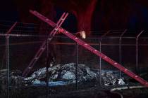 Remnants of an aircraft carrying nine people lies on the ground near a fence that surrounds Dil ...