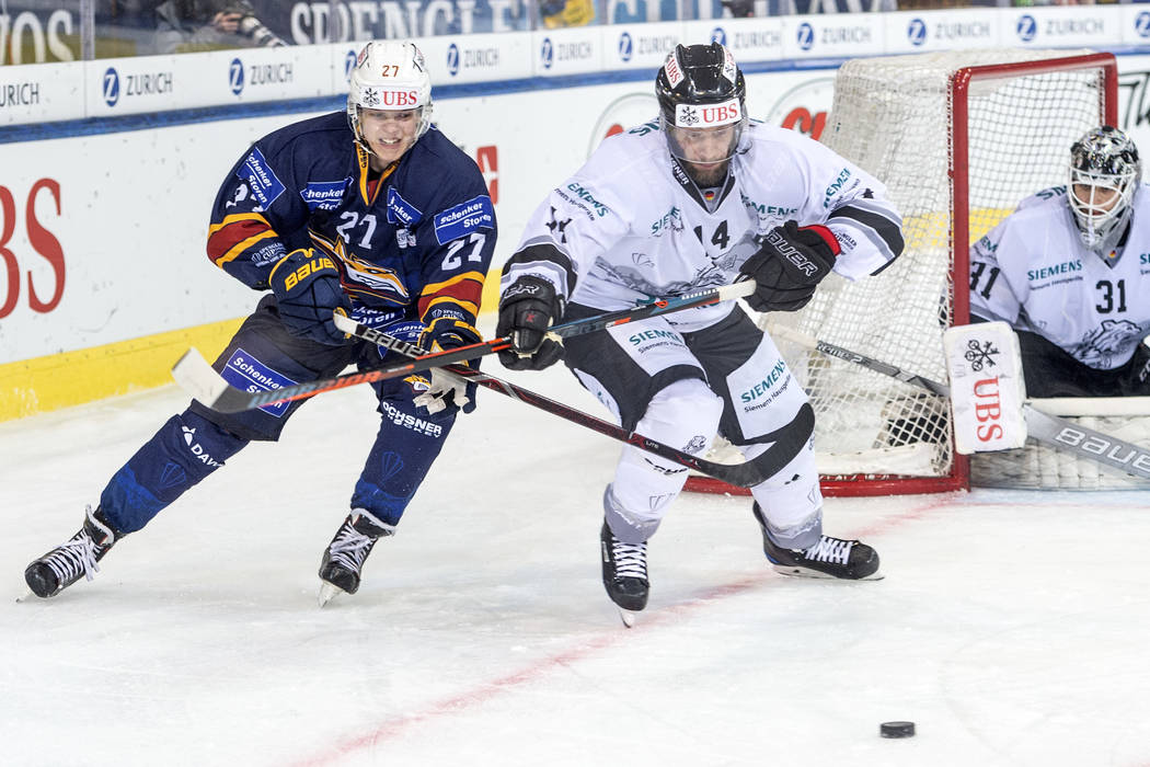 Magnitogorsk's Pavel Dorofeyev, left, against Ice Tigers's Marcus Weber challenge for the puck ...