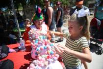 Gianna Bertuccini, 7, picks a lollipop as volunteer Carol Bell looks on during the Founder's Da ...