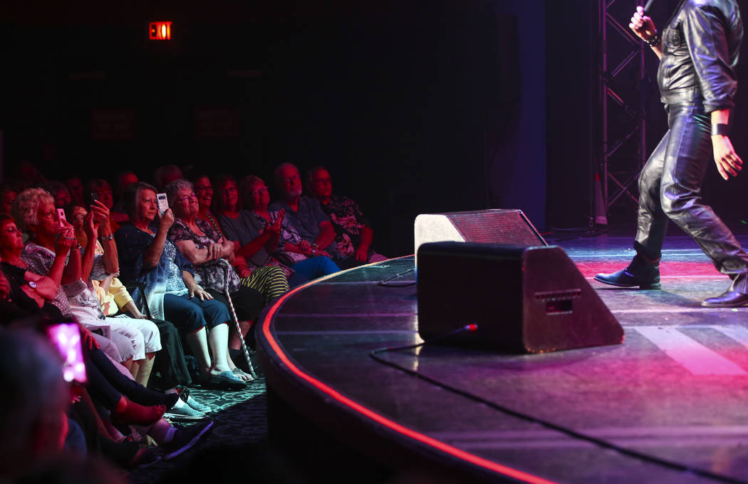 Attendees watch as Rob Ely, of Oakdale, Calif., performs in the '60s era competition during the ...