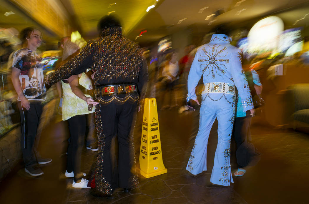Elvis tribute artists talk with hotel guests before performing in the '70s era competition duri ...