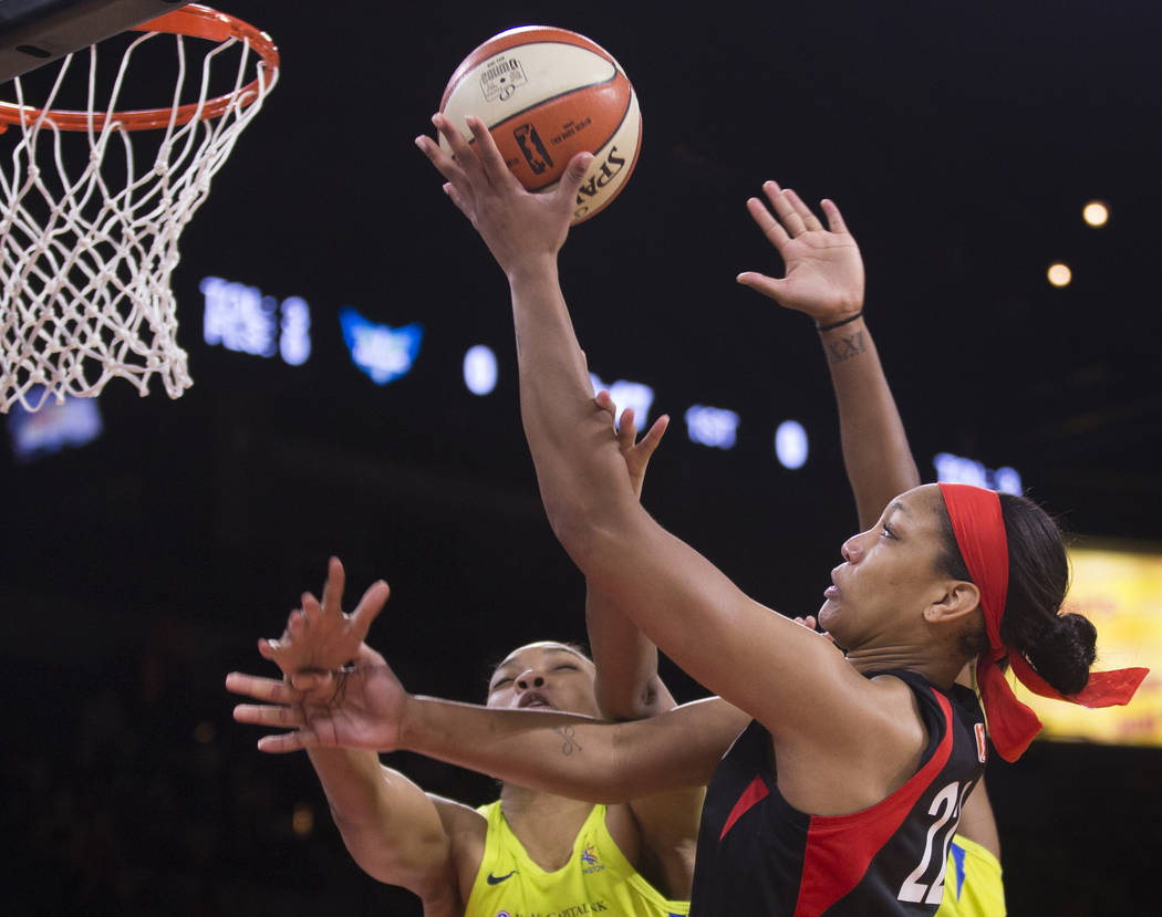 Las Vegas Aces center A'ja Wilson (22) slices to the rim past Dallas Wings center Imani McGee-S ...