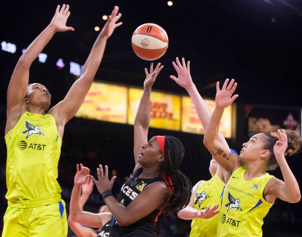 Las Vegas Aces guard Sugar Rodgers (14) splits Dallas Wings center Imani McGee-Stafford (34) an ...