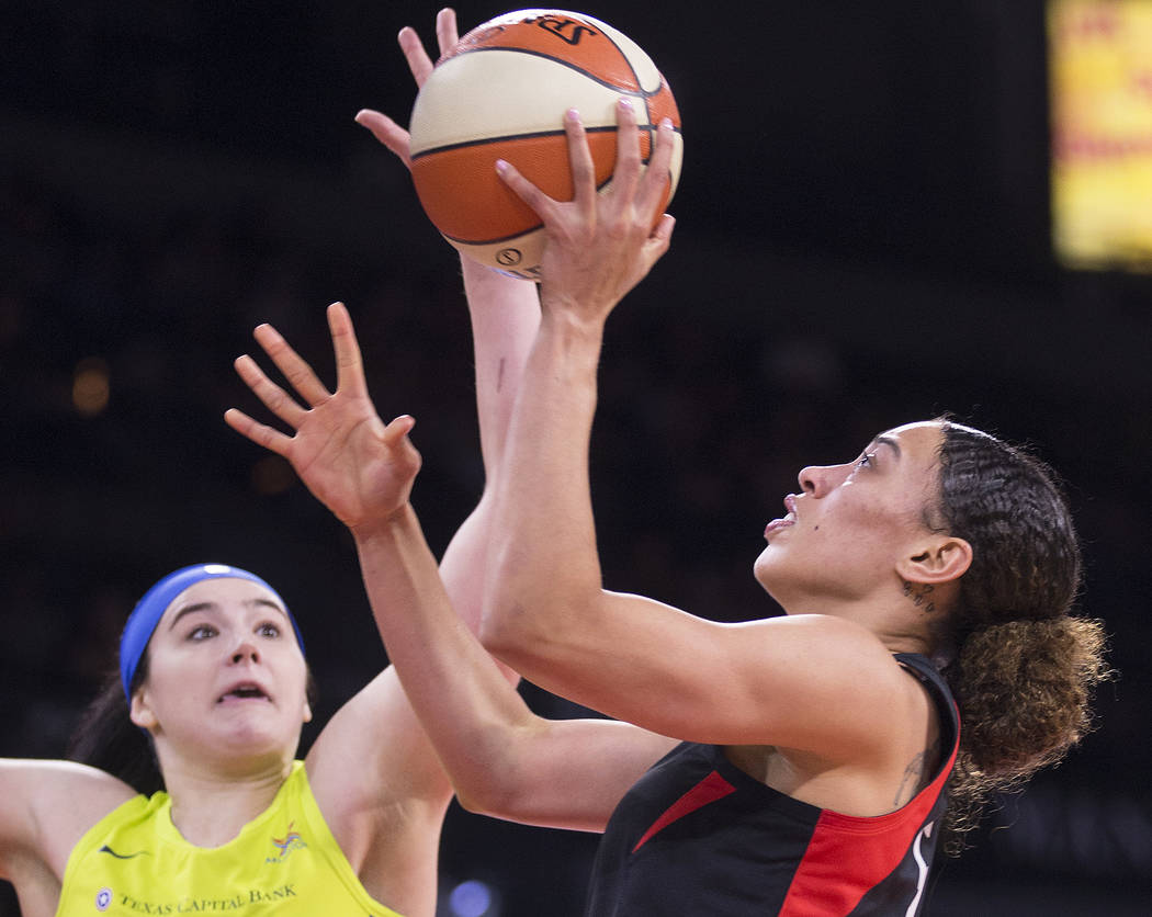 Las Vegas Aces forward Dearica Hamby (5) drives past Dallas Wings forward Megan Gustafson (13) ...