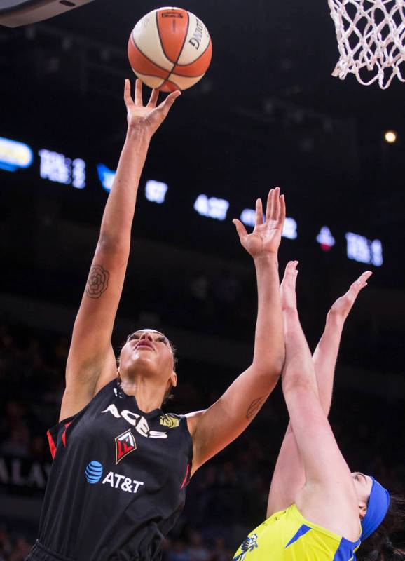 Las Vegas Aces center Liz Cambage (8) drives past Dallas Wings forward Megan Gustafson (13) in ...