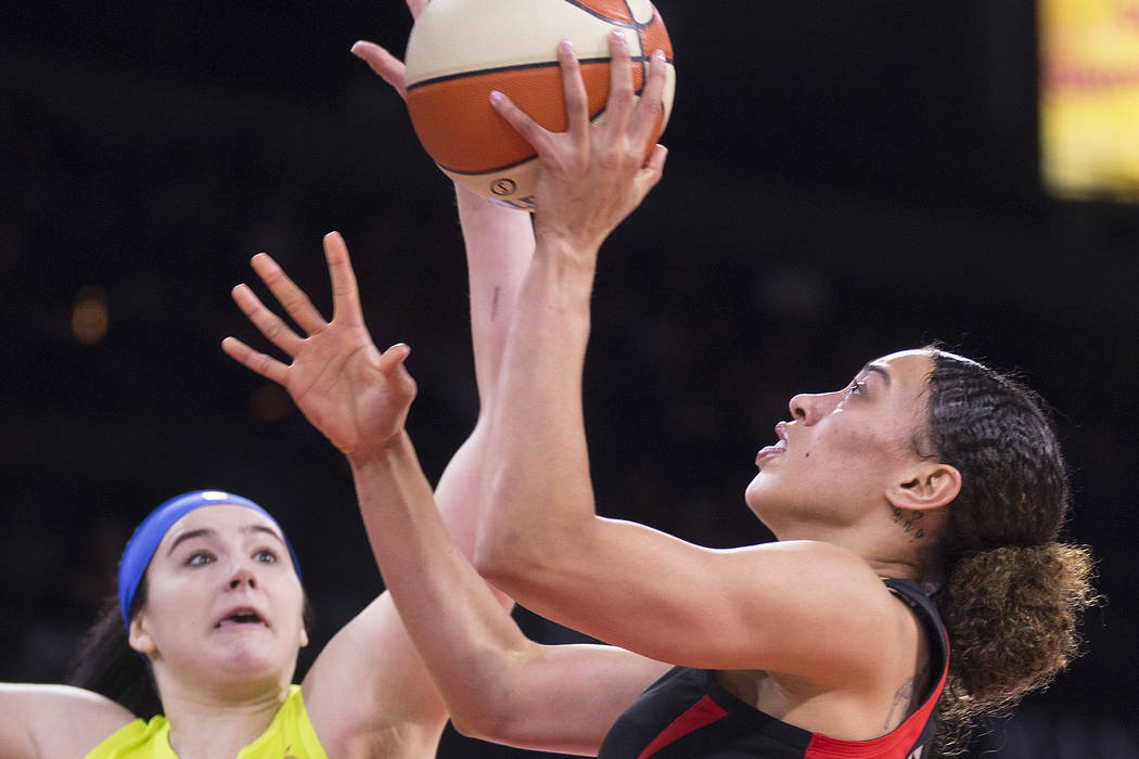 Las Vegas Aces forward Dearica Hamby (5) drives past Dallas Wings forward Megan Gustafson (13) ...