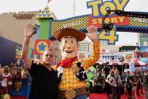 Tom Hanks, left, poses with his character Woody as he arrives at the world premiere of "To ...