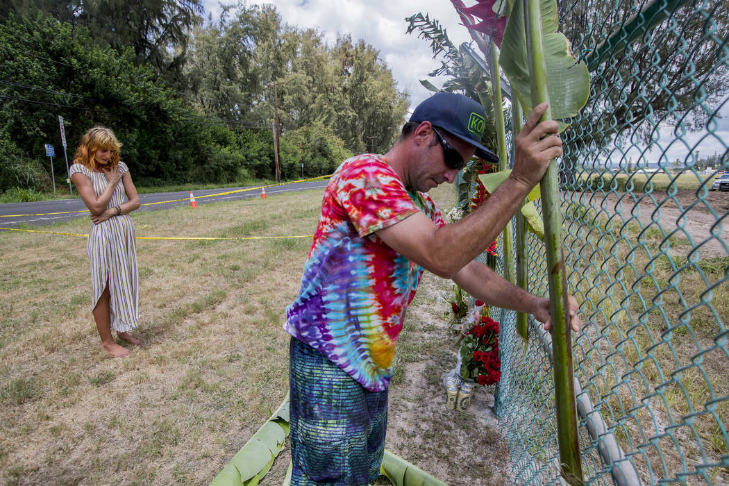 Brian Raley places large flowers and leaves as part of a memorial at the site where a Beechcraf ...