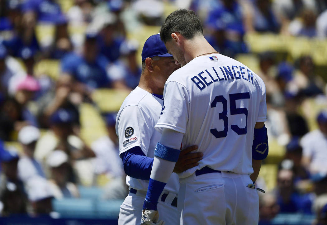 Los Angeles Dodgers manager Dave Roberts, left, talks with Cody Bellinger after Bellinger hit a ...