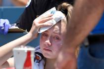A young fan holds ice to her head after being hit with a foul ball hit by Los Angeles Dodgers' ...
