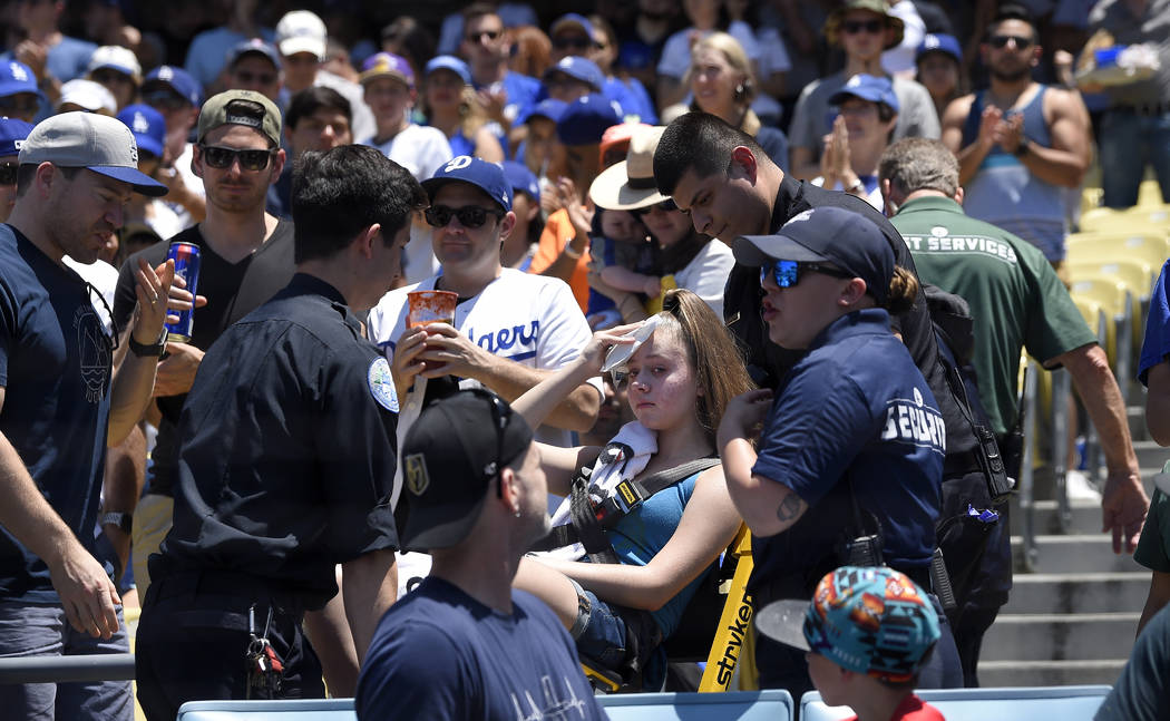 A young fan is carted away after being hit with a foul ball hit by Los Angeles Dodgers' Cody Be ...