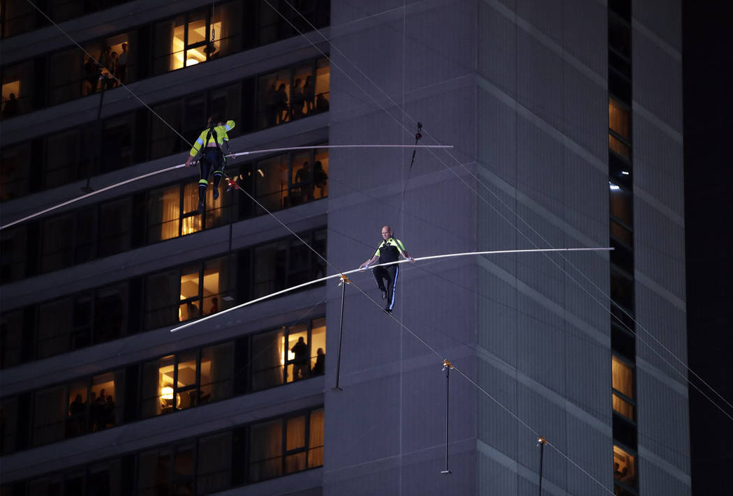 Aerialists Nik Wallenda, right, and his sister Lijana walk on a high wire above Times Square, S ...