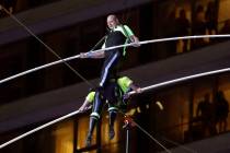 Aerialists Nik Wallenda, top, steps over his sister Lijana as they walk on a high wire above Ti ...