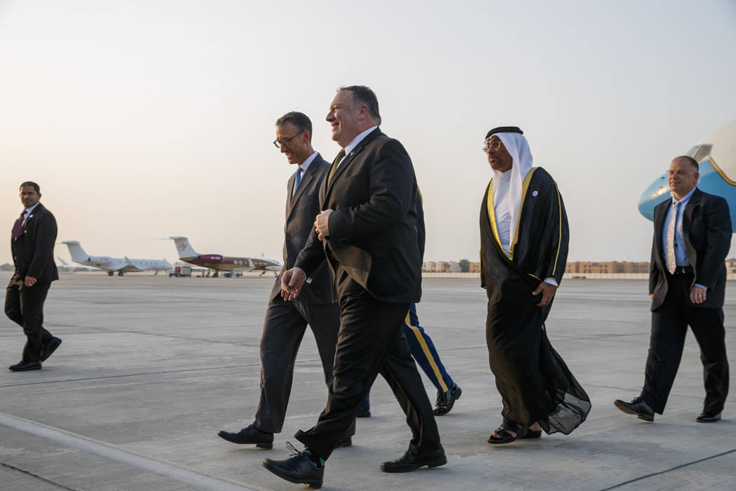 Secretary of State Mike Pompeo, center, walks with U.S. Charge d'Affaires Steve Bondy, left, an ...