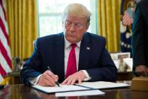President Donald Trump signs an executive order to increase sanctions on Iran, in the Oval Offi ...