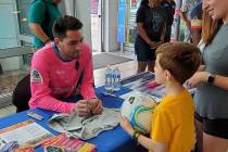 Las Vegas Lights goalie Thomas K. Olsen signs a soccer ball for unidentified young soccer playe ...