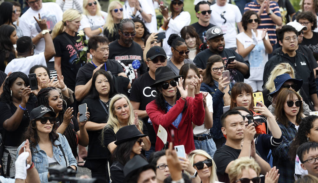 Fans of Michael Jackson including Jackson impersonator Rem Garza, center, stand outside the lat ...