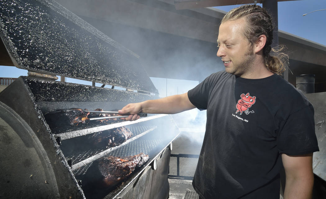 Pit master Dusty Ardoin checks on one of the smokers at Rollin' Smoke Barbeque at 3185 Highland ...