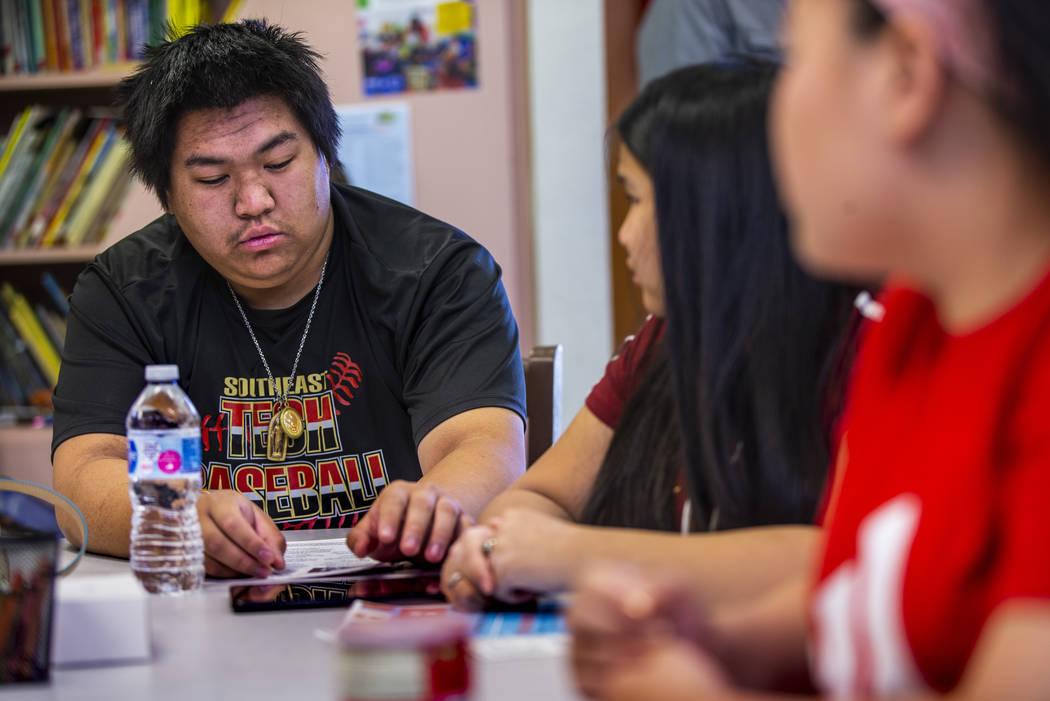 Mark, 17, Jenna, 13, and Lena, 15, Lacksanamyxay learn to operate a free Galaxy tablet and inte ...