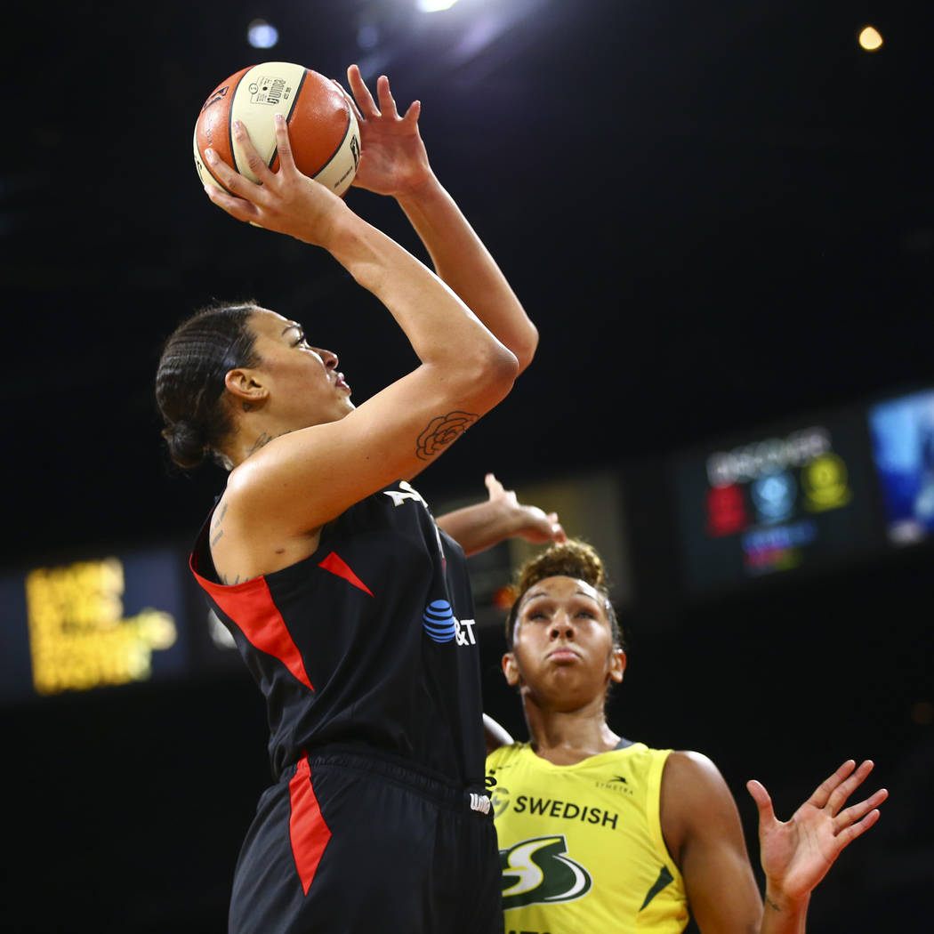 Las Vegas Aces center Liz Cambage, left, shoots over Seattle Storm center Mercedes Russell duri ...