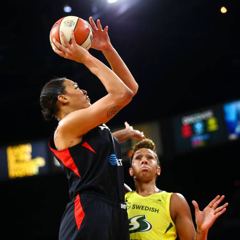Las Vegas Aces center Liz Cambage, left, shoots over Seattle Storm center Mercedes Russell duri ...