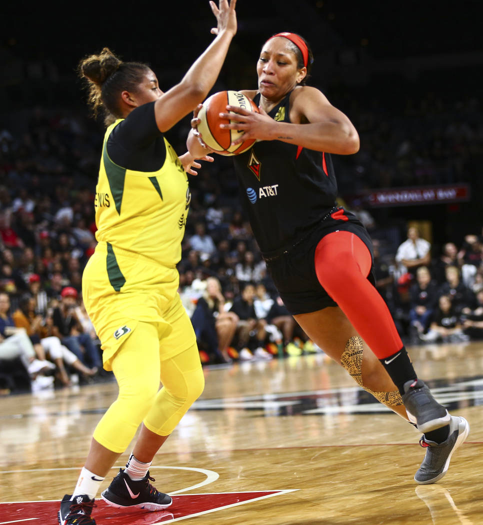 Las Vegas Aces center A'ja Wilson, right, drives to the basket against Seattle Storm forward Ka ...