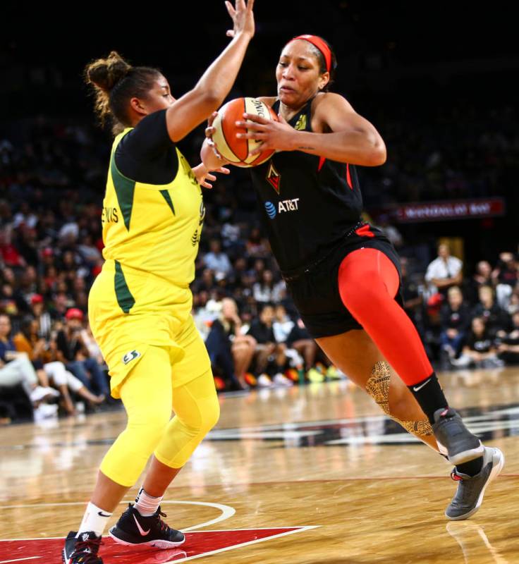 Las Vegas Aces center A'ja Wilson, right, drives to the basket against Seattle Storm forward Ka ...