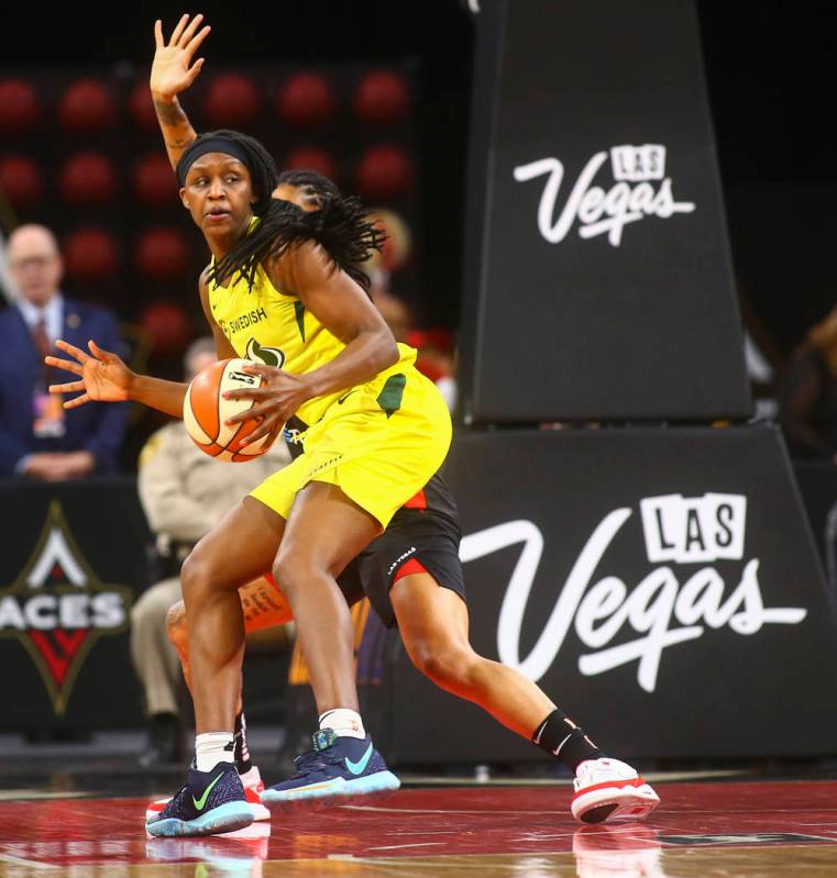 Seattle Storm forward Crystal Langhorne moves the ball around a Las Vegas Aces defender during ...
