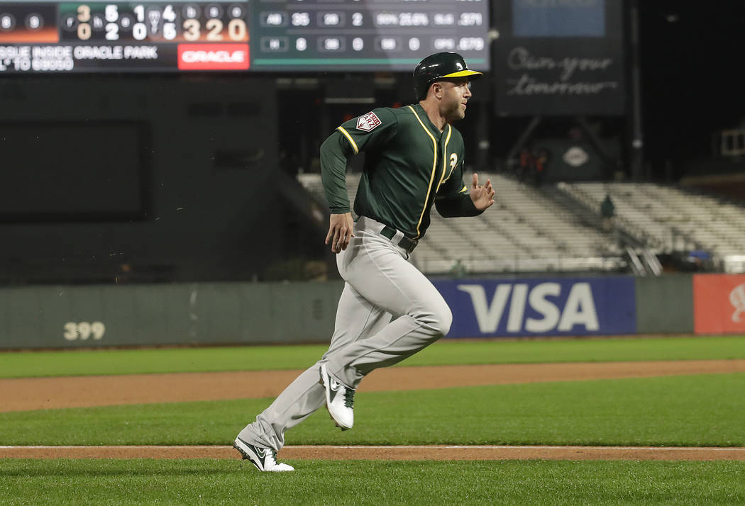 Oakland Athletics' Eric Campbell scores against the San Francisco Giants during the seventh inn ...