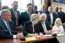 University of Connecticut President Susan Herbst, seated center, signs a contract on Wednesday, ...