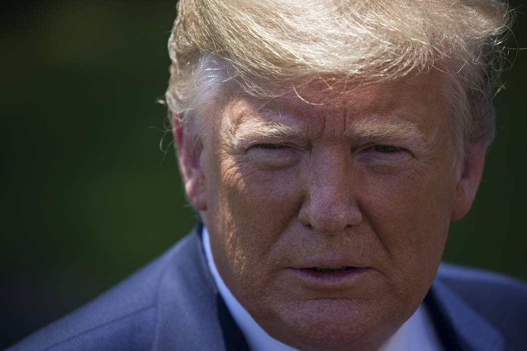 President Donald Trump listens to a question as he speaks with reporters on the South Lawn of t ...