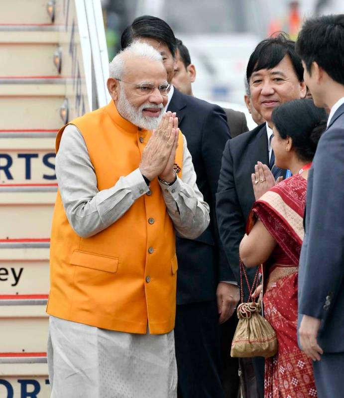 Indian Prime Minister Narendra Modi is greeted on his arrival at Kansai International Airport i ...