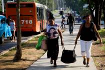 Women carry a bag after arriving by bus to Havana, Cuba, Thursday, June 27, 2019. Cuban Preside ...
