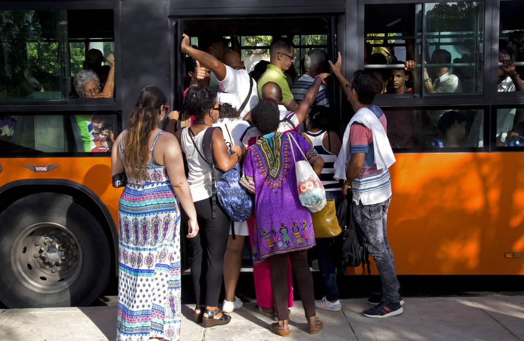 People squeeze on to a bus in Havana, Cuba, Thursday, June 27, 2019. Cuban President Miguel D&# ...