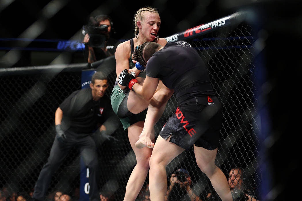 Emily Whitmire, left, connects a knee against Jamie Moyle in the womenÕs strawweight bout ...