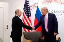 U.S. President Donald Trump, right, shakes hands with Russian President Vladimir Putin during a ...