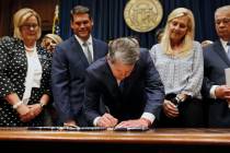 In a May 7, 2019, file photo, Georgia's Republican Gov. Brian Kemp, center, signs legislation i ...
