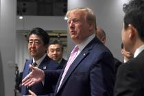 President Donald Trump, walking with Japanese Prime Minister Shinzo Abe stops to ask a question ...
