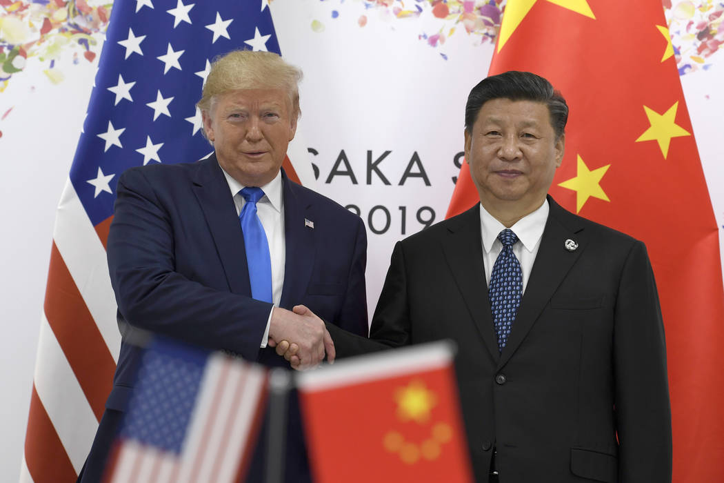 President Donald Trump, left, shakes hands with Chinese President Xi Jinping during a meeting o ...