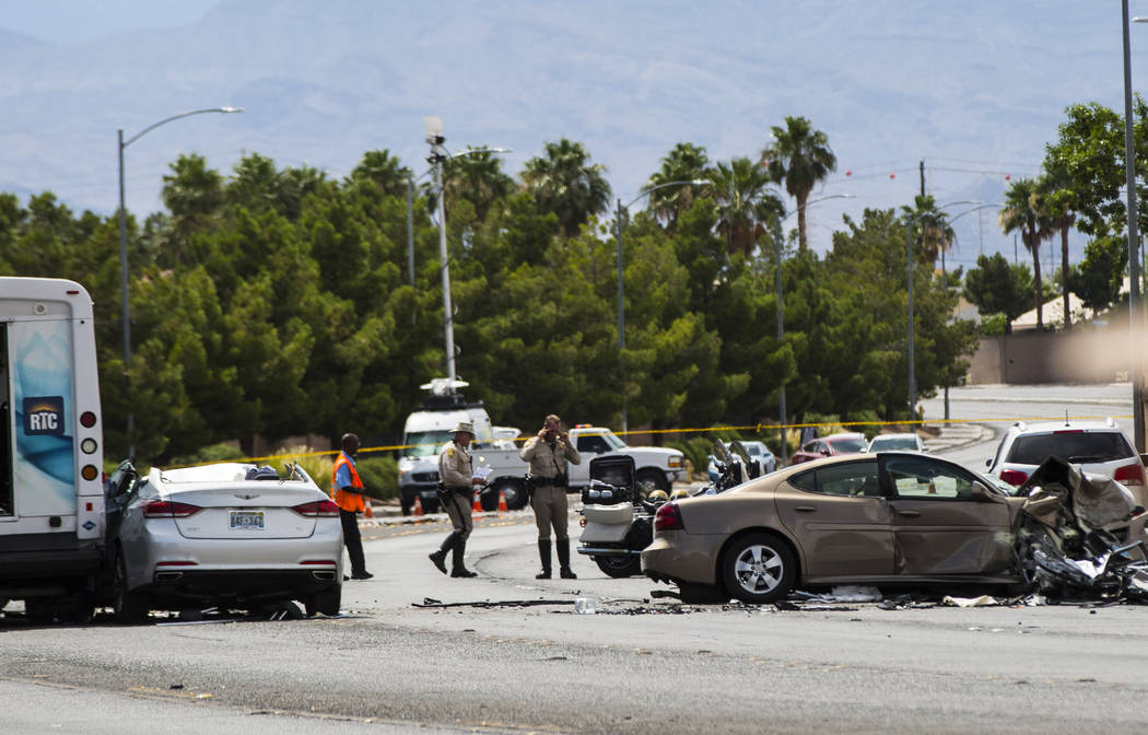 Las Vegas police investigate the scene of an accident involving three cars and a bus on Lake Me ...