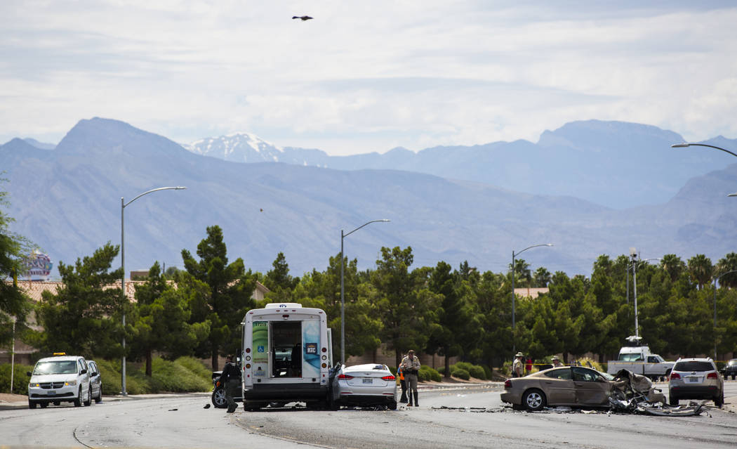 Las Vegas police investigate the scene of an accident involving three cars and a bus on Lake Me ...