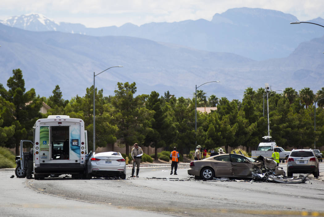 Las Vegas police investigate the scene of an accident involving three cars and a bus on Lake Me ...