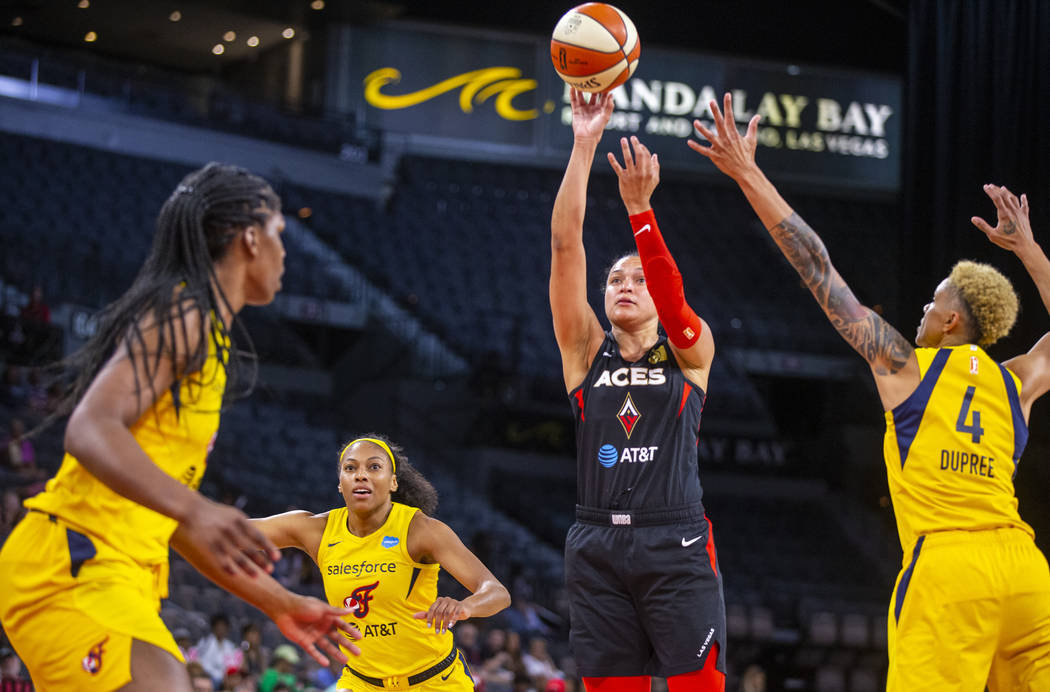 Las Vegas Aces guard Kayla McBride gets off a shot over Indiana Fever defenders during the firs ...