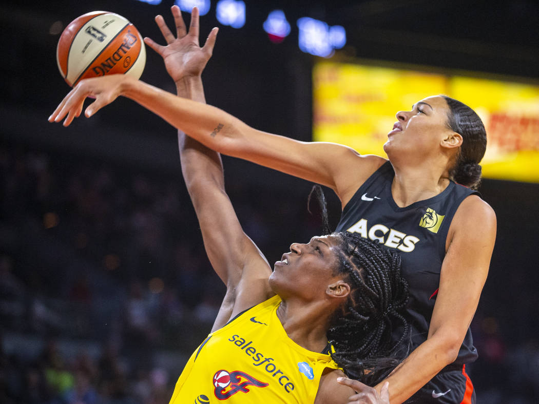 Las Vegas Aces center Liz Cambage, right, deflects a shot by Indiana Fever center Teaira McCowa ...