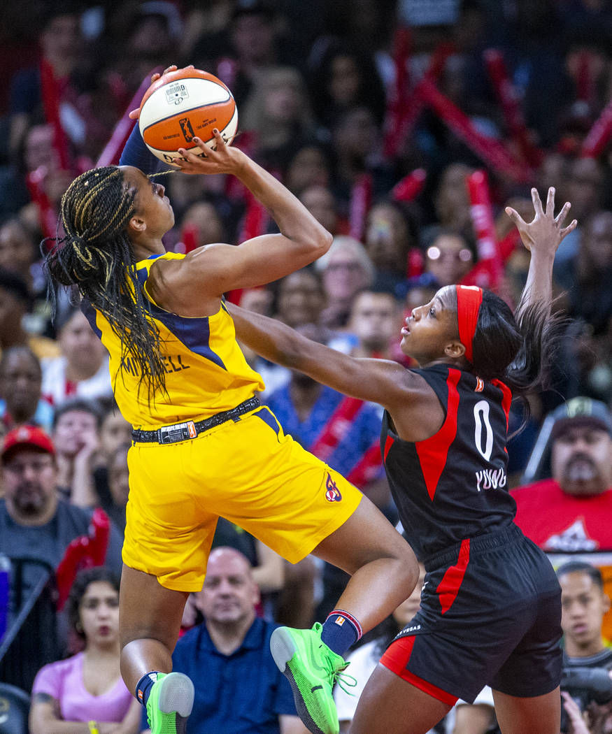 Indiana Fever guard Kelsey Mitchell (0) is defended on a shot by Las Vegas Aces guard Jackie Yo ...