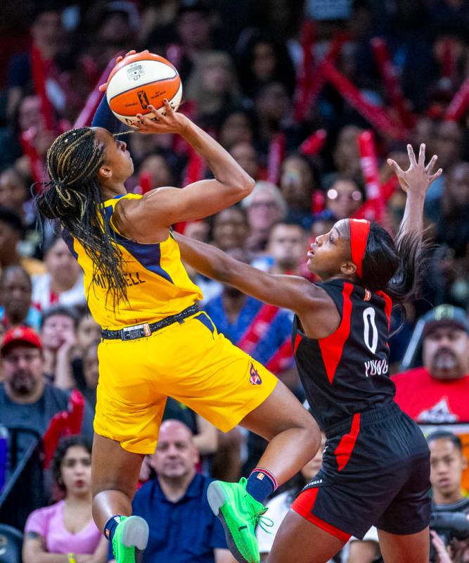 Indiana Fever guard Kelsey Mitchell (0) is defended on a shot by Las Vegas Aces guard Jackie Yo ...